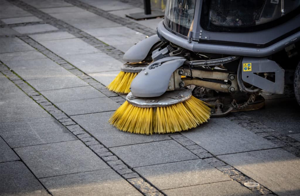 brosses de balayeuse professionnelle de voirie en train de nettoyer le sol